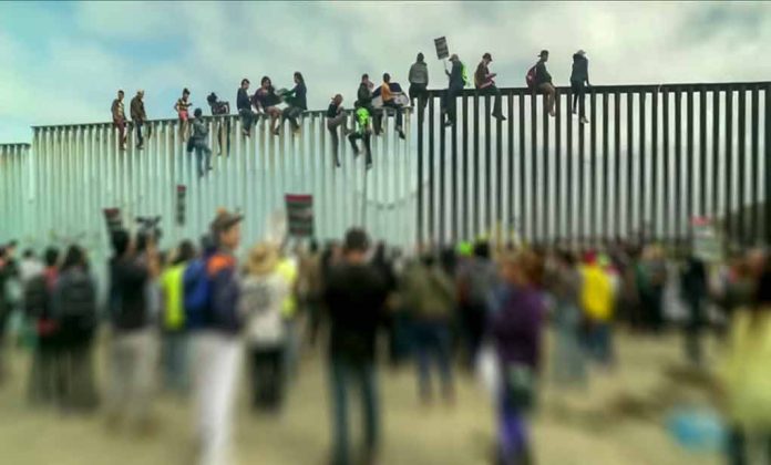 People sitting on high metal fence during protest