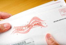 Hands holding official election mail envelope