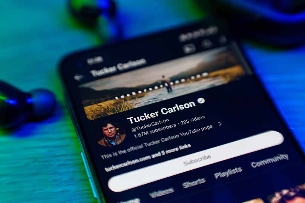 Smartphone showing Tucker Carlson's YouTube channel.
