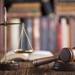 Gavel and scales on desk with books