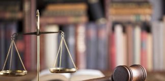 Gavel and scales on desk with books