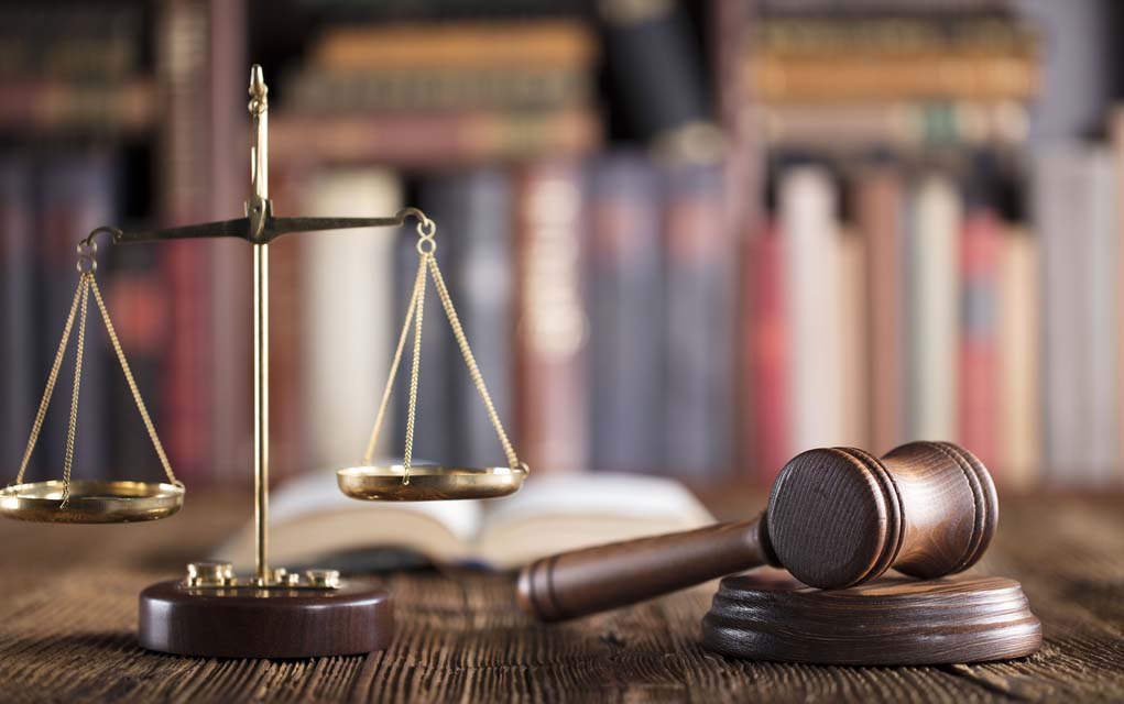 Gavel and scales on desk with books