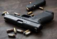 Handgun with bullets on a wooden surface.