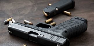 Handgun with bullets on a wooden surface.