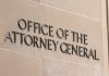 Office of the Attorney General sign on concrete wall.