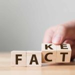 Hand flipping blocks between fact and fake