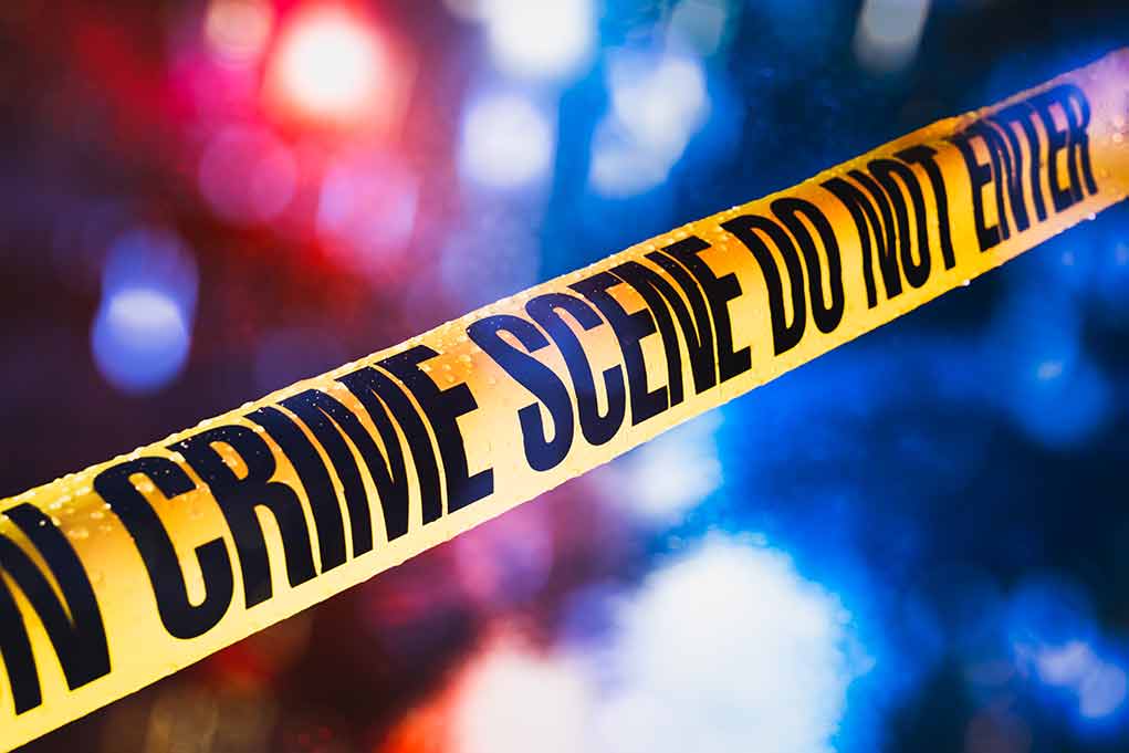 Yellow crime scene tape with blurred lights background