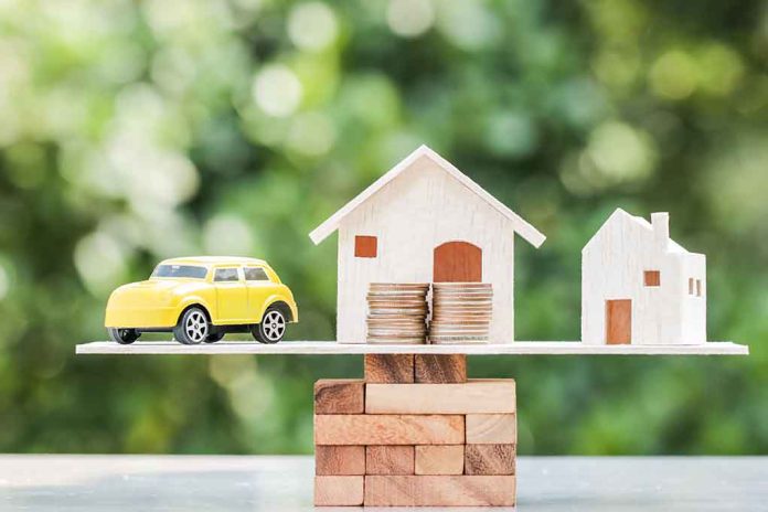 Toy car and houses balanced on stacked coins.