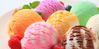 Assorted ice cream scoops with raspberries on a plate.