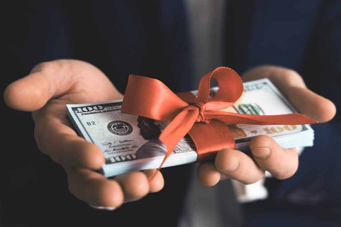 Hands holding stack of hundred-dollar bills with ribbon.