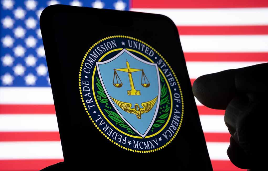 FTC logo on smartphone with American flag background.