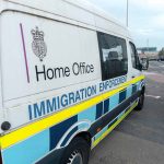 White immigration enforcement van parked by roadside