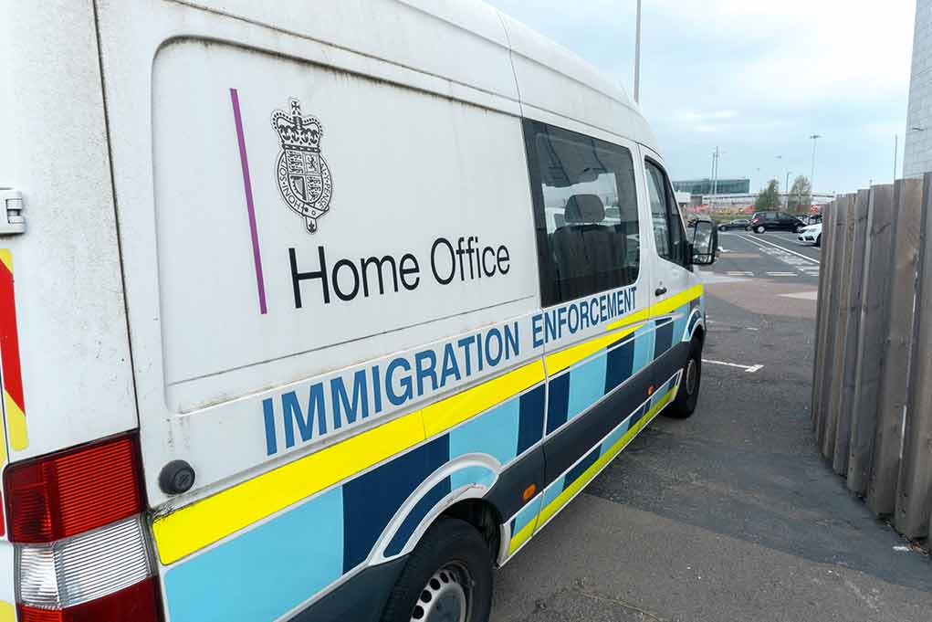 White immigration enforcement van parked by roadside