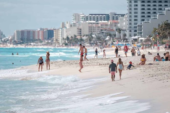 People walking and relaxing on a crowded beach.