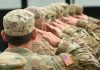 Soldiers in uniform saluting with American flag patch