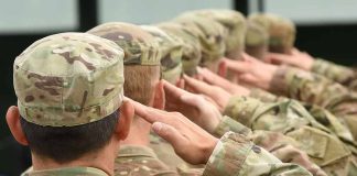 Soldiers in uniform saluting with American flag patch