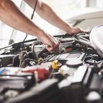 Mechanic working on an engine in a car.