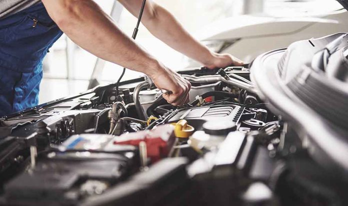 Mechanic working on an engine in a car.