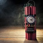 Dynamite bundle with a clock timer on wooden floor.