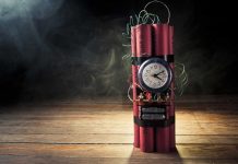 Dynamite bundle with a clock timer on wooden floor.