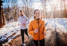 Two people jogging on a snowy path outdoors