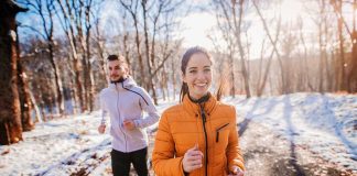 Two people jogging on a snowy path outdoors