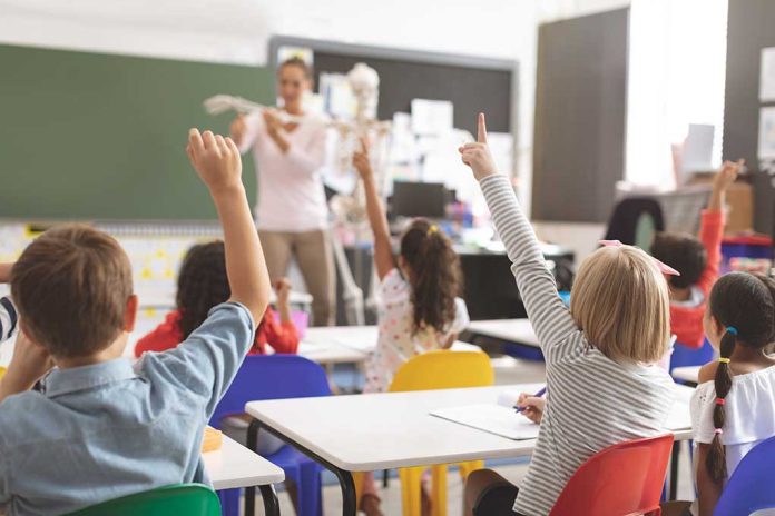 Children raising hands in classroom.