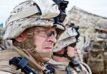 Military personnel in camouflage gear and helmets outdoors