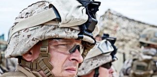 Military personnel in camouflage gear and helmets outdoors