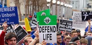 Pro-life rally with people holding various signs.