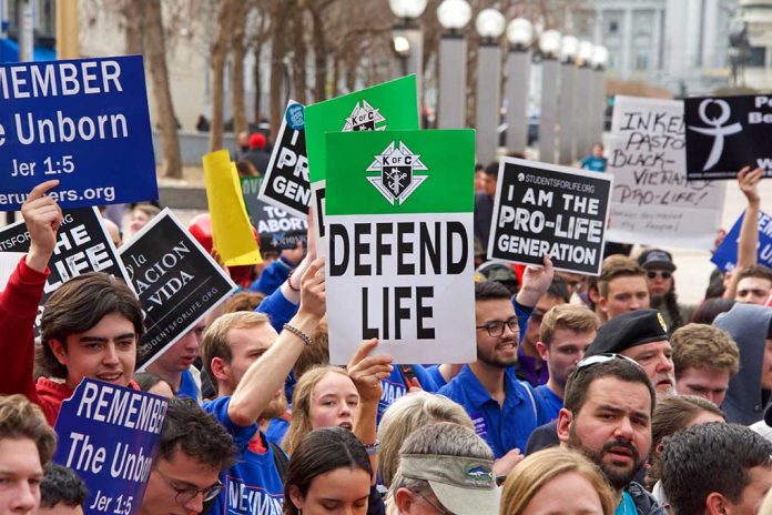 Pro-life rally with people holding various signs.