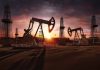 Oil pumps operating at sunset in a desert.