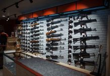 Wall display of various rifles in a gun store.