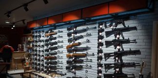 Wall display of various rifles in a gun store.