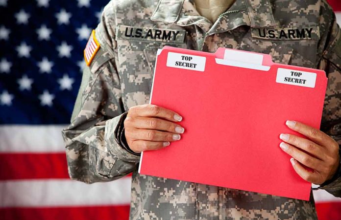 U.S. Army soldier holds a "Top Secret" folder.