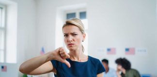 Woman with thumbs down in voting location.