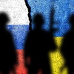 Silhouettes against Russian and Ukrainian flags with crack