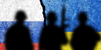 Silhouettes against Russian and Ukrainian flags with crack