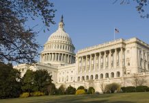 United States Capitol building with surrounding trees.