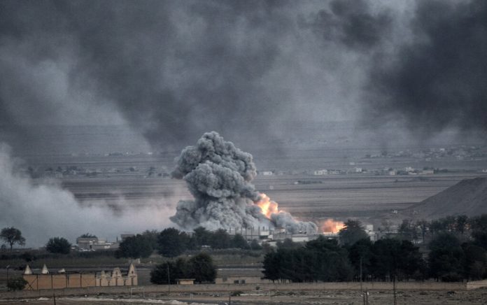 Explosion with smoke and fire in open landscape.