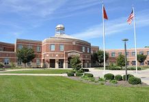 School building with flags and clear sky