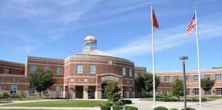 School building with flags and clear sky