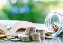 Open book pen coins jar on table