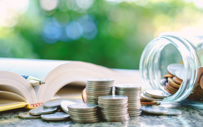 Open book pen coins jar on table