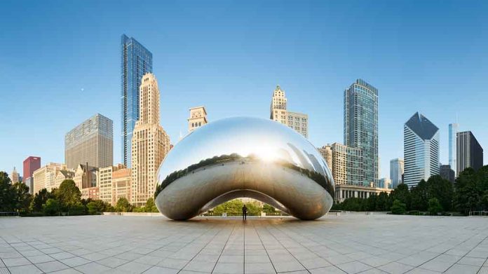 Cloud Gate sculpture with skyline of skyscrapers behind it.