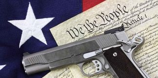 Gun on U.S. Constitution and flag.