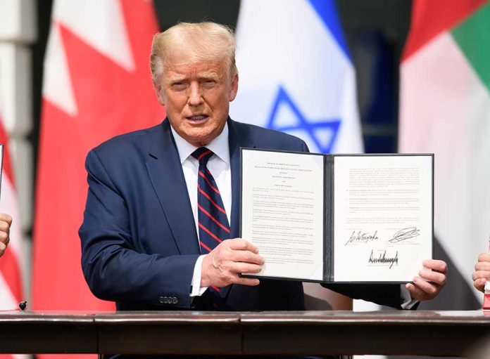 Person in blue suit holding signed document in ceremony