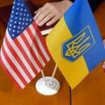 US and Ukraine flags on wooden table meeting