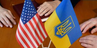 US and Ukraine flags on wooden table meeting