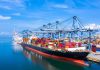 Container ship docked at a busy industrial port.